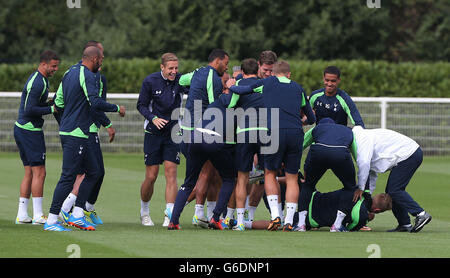 Lewis Holtby di Tottenham Hotspur (piano) celebra oggi il suo 23° compleanno con una corsa attraverso un tunnel dei suoi compagni di squadra, tra cui Kyle Walker (a sinistra) e Michael Dawson (quarta a sinistra) durante la sessione di allenamento presso l'Enfield Training Ground, Londra. Foto Stock