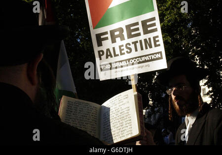 Un rabbino legge i salmi della Tora, mentre un gruppo di ebrei pro-palastiniani si unisce alla manifestazione fuori dalle porte di Downing Street, prima dell'arrivo del primo ministro israeliano, Ariel Sharon. Il primo ministro Tony Blair ha tenuto oggi colloqui con il suo omologo israeliano, *..Ariel Sharon, volti a migliorare le relazioni strette con la Gran Bretagna e a far progredire il processo di pace in Medio Oriente. La visita di Sharon a Londra, durante la quale ha incontrato anche il Ministro degli esteri Jack Straw, si scontra con i problemi in corso nell'attuazione del piano internazionale di "Road map" per porre fine al conflitto Foto Stock