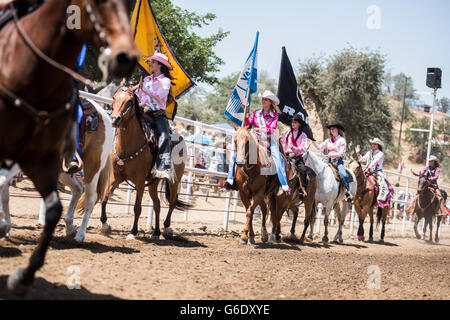 Cowgirls cavalcare i loro cavalli durante un procedimento presso il Lions Woodlake Rodeo rodeo in Woodlake, California, il 10 maggio 2015. Foto Stock