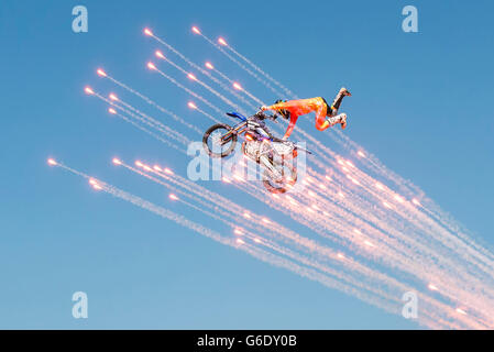 Uno stunt motocross rider fa un'antenna di manovra come fuochi d'artificio esplodere intorno a lui durante la finale del Lions Woodlake Rodeo rodeo in Woodlake, California, il 10 maggio 2015. Foto Stock