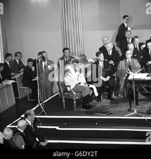 Il presidente AMERICANO JOHN F. KENNEDY aggiusta le sue vesti accademiche alla cerimonia a Dublino in cui ha ricevuto due gradi onorari di dottore di legge. Indossò delle scarlatto per ricevere il titolo di National University of Ireland, poi, dopo aver lasciato la piattaforma, si trasformò in scarlatto e abiti rosa per ricevere il titolo di Università di Dublino. 28 giugno 1963 PAR 103890-23 (esh/PNR/P-R) Foto Stock