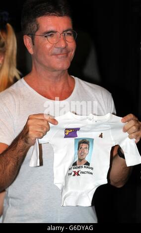Simon Cowell tiene un babygrow in una foto-call al RADA di Londra per lanciare l'X Factor Musical 'i Cant sing'. Foto Stock