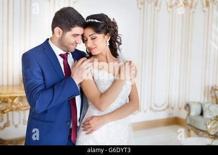 Lo sposo abbraccia delicatamente e bacia la sposa Foto Stock