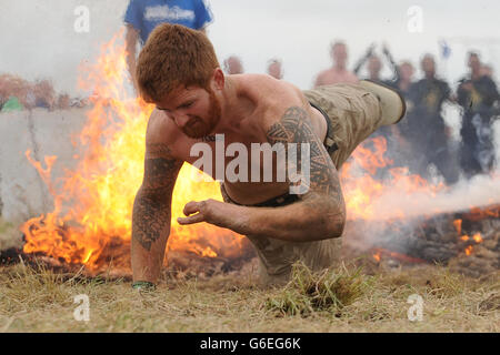 Lance Bombardier James Simpson affronta l'ostacolo al fuoco durante la Spartan Super Race presso il West Midlands Water Ski Center, Warwickshire. PREMERE ASSOCIAZIONE foto. Data immagine: Sabato 21 settembre 2013. Il credito fotografico dovrebbe essere: Joe Giddens/PA Wire Foto Stock