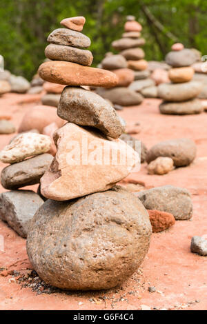 Un raggruppamento di piccoli cairns vicino a Oak Creek su rocce rosse attraversando escursione in Sedona, AZ. Foto Stock