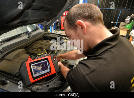 Un meccanico utilizza un sistema informativo di diagnostica modulare MODIS a scatto sui componenti elettronici di un'auto Foto Stock