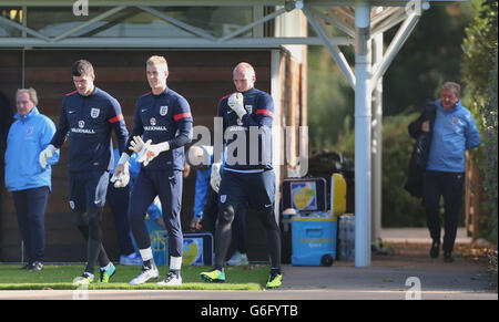 In Inghilterra i portiere sono sotto la guida di Joe Hart (centro) John Ruddy e Fraser Forster (sinistra) con il manager Roy Hodgson (destra) che lascia lo spogliatoio prima della sessione di formazione a London Colney, Londra. Foto Stock