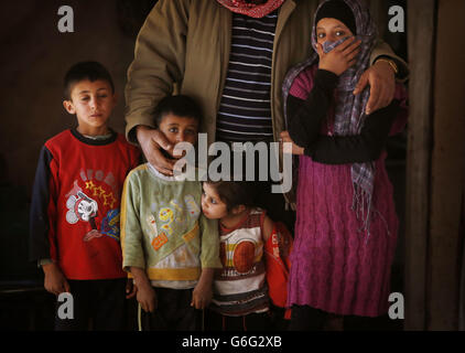 Il rifugiato siriano Ahmad Salameh Shekho con i suoi figli (da sinistra a destra) Mohammed, Khaled, Ftem e Salam in un alloggio di tre camere di rifugiati di fortuna nella valle di Bekaa, in Libano, dove a sei famiglie viene addebitato 133 dollari americani al mese per affittare la terra. Foto Stock