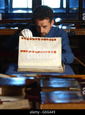 Martin Clayton, curatore della sala stampa del Castello di Windsor, prepara un libro contenente firme e sigilli di negoziatori coinvolti nel trattato dell'Unione nel 1706, in vista di una mostra che inizia questo fine settimana per celebrare il 400° anniversario dell'Unione delle corone al Castello di Windsor, Berkshire. I visitatori del Castello di Windsor potranno dare un'occhiata ai disegni, ai libri e ai documenti raccolti dai re e dalle regine Stuart durante il loro regno di 100 anni. La collezione, di proprietà della Regina, che per la prima volta viene vista dal pubblico, riflette i violenti sconvolgimenti politici Foto Stock