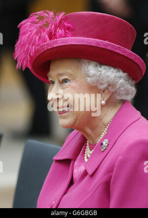 La regina Elisabetta II guarda un'esecuzione di una canzone del musical 'Guys and Dolls, durante una visita al Teatro Nazionale di Londra, per commemorare il 50 ° anniversario dell'istituzione. Foto Stock