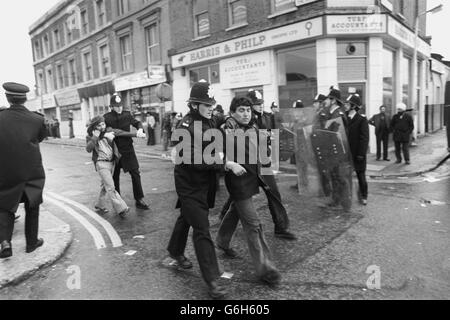 La polizia con scudi antisommossa sta accanto ai dimostranti che si accamparono ai furgoni in attesa a Southall dopo che una battaglia a colpi di falco ha scoppiato il municipio locale dove si stava svolgendo un raduno sul fronte nazionale. Numerosi poliziotti e manifestanti sono stati feriti durante i combattimenti. Foto Stock