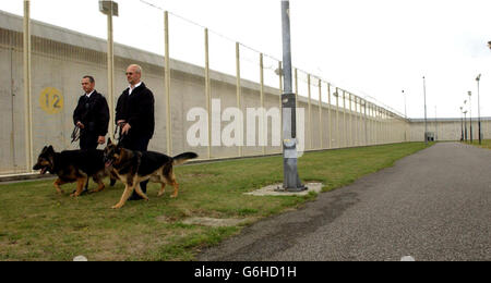 Gli ufficiali di gestione dei cani pattugliano alla prigione locale di alta sicurezza, HMP Belmarsh, a Thamesmead , Londra orientale. Il governatore della prigione di Belmarsh ha detto oggi di essere stato "spronato” dalle critiche alla sicurezza sollevate alla sua prigione in un nuovo rapporto. Geoff Hughes ha detto che il team guidato dal Chief Ispettore delle Grigioni Anne owers potrebbe aver frainteso la gerarchia di sicurezza nel sud-est di Londra massima prigione di sicurezza. Foto Stock