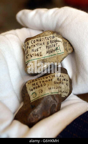 Un paio di pietre che sono state gettate attraverso le finestre di Buckingham Palace protestando suffragette nel 1914 sono tenute da un membro del personale della collezione reale nel salotto bianco di Buckingham Palace. Le piccole rocce, ciascuna lunga circa tre pollici, sono state conservate per i posteri dalla Regina Maria e sono ora tra gli oggetti insoliti degli archivi reali che vanno in mostra alla residenza della Regina di Londra. Circa 150 oggetti saranno esposti in un ricevimento speciale ospitato dalla Regina rendendo omaggio al contributo di più di 400 pionieri nella vita britannica. Foto Stock