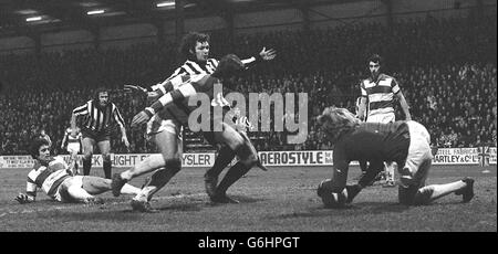 Attack by Notts County (Stripes) si ferma mentre Phil Parkes, portiere del Queen's Park Rangers, si tuffa sulla palla nel quarto round fa Cup tie a Loftus Road, Shepherd's Bush. Frank McLintock, il numero 5 di Rangers, a terra, guarda sulla sinistra. QPR ha vinto 3-0. Foto Stock