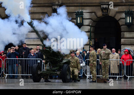 I membri del pubblico si levano in piedi per osservare l'inizio di un silenzio di due minuti segnato dal fuoco del cannone durante le commemorazioni del giorno dell'Armistizio nel centro della città di Nottingham. Foto Stock