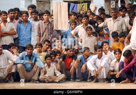 Una grande folla si raccoglie mentre il Principe del Galles procede in una passeggiata attraverso le strade del villaggio di Kutail Gamri, alla periferia di Delhi, India, come parte della sua visita nella zona. Foto Stock