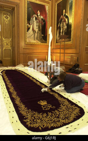 Il vestito di coronazione e il Robe of Estate della Regina Elisabetta II è controllato su Faye Dryden (a sinistra) e Christine Housden, conservatore tessile dei palazzi reali storici, a Hampton Court, prima che il vestito e il Robe vadano in mostra al Castello di Windsor l'8 ottobre fino al 4 gennaio 2004, Lunedì 6 ottobre 2003. A causa del popolare fascino della cerimonia e delle celebrazioni: Incoronazione il giorno 1953 all'apertura estiva delle sale Sate a Buckingham Palace (aperto fino al 28 settembre 2003), queste accappatoi continueranno ad essere esposte fino alla fine dell'anno dell'incoronazione nella Sala del Garrone del Castello di Windsor. Foto Stock