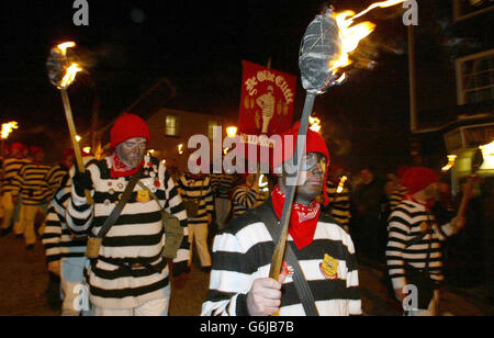 I membri della Cliffe Bonfire Society marciano per le strade di Lewes, nel Sussex orientale, con fiammeggianti torce per celebrare la folgorazione del complotto di polvere da sparo di Guy Fawkes per distruggere il parlamento nel 1605. Foto Stock