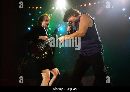 Il cantante australiano Brian Johnson (a destra) e il chitarrista Angus Young si esibiscono in concerto al Carling Hammersmith Apollo, nella zona ovest di Londra. Foto Stock