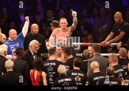 George Groves (in alto al centro) sorge sopra Carl Froch (in basso al centro) e la sua squadra dopo aver perso la WBA e IBF Super Middleweight Title Fight alla Phones 4u Arena, Manchester. Foto Stock