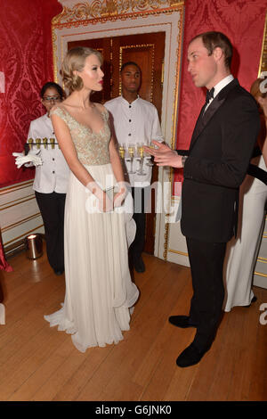 Il Duca di Cambridge incontra Taylor Swift (a sinistra) mentre frequenta la cena di gala Centrepoint a Kensington Palace, Londra. Foto Stock