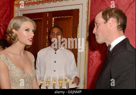 Il Duca di Cambridge incontra Taylor Swift (a sinistra) mentre frequenta la cena di gala Centrepoint a Kensington Palace, Londra. Foto Stock