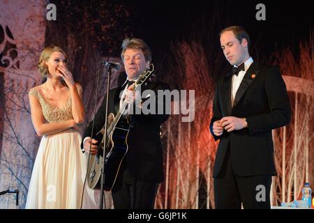 The Duke of Cambridge (a destra) e Taylor Swift (a sinistra) Ascolta Jon Bon Jovi suona un solista di chitarra durante uno spettacolo al Centrepoint Gala Dinner al Kensington Palace di Londra. Foto Stock