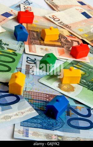 Case in miniatura sulle banconote in euro, immagine simbolica real estate Foto Stock