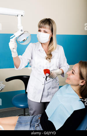 La reception era presso il dentista femmina. Medico esamina la cavità orale su carie. Protezione della carie. medico mette il paziente di una iniezione di anestetico. Foto Stock