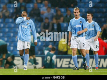 Nicolas Anelka, Paul Bosvelt e Joey Barton mostrano il loro rifiuto dopo che Groclin Dyskobolia ha segnato da un calcio di punizione, durante la Coppa UEFA, 2° turno, 1° incontro al City of Manchester Stadium. Foto Stock