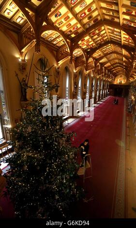 L'amministratore della mostra Royal Collection Roxy Hackett applica i tocchi finali a un albero di Natale Nordman Fir di sei metri nella St George's Hall, che fa parte della mostra natalizia al Castello di Windsor, nel Berkshire. Foto Stock