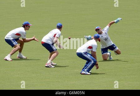 L'inglese Alastair Cook (a sinistra) Graeme Swann (seconda a sinistra) e Joe Root (seconda a destra) osservano come Matt Prior (a destra) perde una presa durante una sessione di pratica all'Adelaide Oval, Adelaide, Australia. Foto Stock