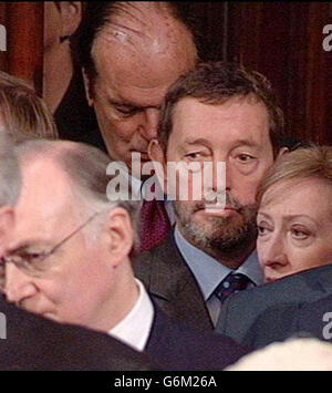 Il segretario all'interno David Blunkett (al centro), Michael Howard, leader dell'opposizione (sinistra), e Margaret Beckett MP, si levano in piedi come la regina Elisabetta II del Regno Unito fa il discorso della regina ai membri della Camera del Signore e della Camera dei Comuni durante l'apertura di Stato del Parlamento a Londra. Seduta sul trono della Camera dei Lord, ha formalmente annunciato il programma legislativo del governo britannico per la nuova sessione parlamentare. Foto Stock