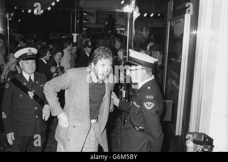 La rock star Pete Townshend, dell'OMS, arrestata da un commissariato che vuole vedere il suo biglietto come è arrivato al Plaza One Cinema di Lower Regent Street, Londra, per partecipare alla prima mondiale di Quadrophenia, un film basato sull'album dell'OMS con lo stesso nome. Townshend ha prodotto silenziosamente il suo biglietto ed è entrato a far parte del pubblico stellato. Foto Stock