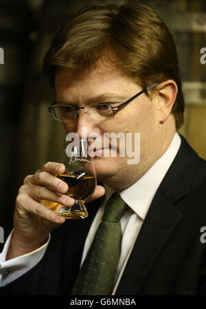 Il Segretario principale del Tesoro Danny Alexander annuisce un whisky di Benromach nel negozio di riempimento durante una visita alla distilleria di Benromach a Forres, vicino Inverness, mentre lancia il programma di verifica delle bevande spiritose. Foto Stock