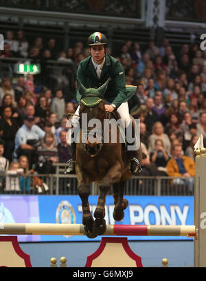 L'irlandese Gerald Clarke Riding Zanzibar V salta una recinzione nella competizione JJ Jumping Pony Club Mini-Major durante il terzo giorno del London International Horse Show, presso l'Olympia Exhibition Hall, West Kensington, Londra. Foto Stock