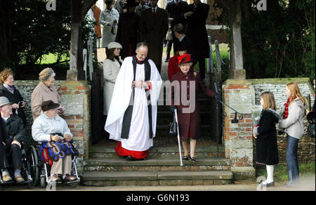 Il Rettore Jonathan Riviere di Sandringham il gruppo delle parrocchie parte accompagna la Regina Elisabertica II della Gran Bretagna, dalla Chiesa di Santa Maria Maddalena nella tenuta reale di Sandringham, Norfolk, dopo il servizio del giorno di Natale a cui hanno partecipato i membri della Famiglia reale. La regina ha fatto oggi la sua prima apparizione pubblica da quando è sottoposto ad un intervento chirurgico sul ginocchio e sul viso. È arrivata per il servizio in macchina con la Contessa di Wessex. Foto Stock