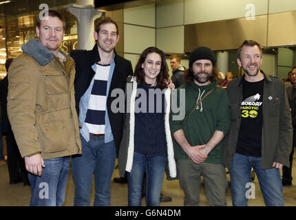 Videografo freelance Kieron Bryan (seconda a sinistra) con attivisti di Greenpeace, Anthony Perrett (a sinistra), Alexandra Harris, Iain Rogers e Phil Ball (a destra), quando arrivano alla stazione di St Pancras, Londra, dopo essere stati trattenuti in Russia come parte del cosiddetto "Arctic 30". Foto Stock