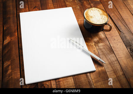 Vuoto modello di branding su vintage tavolo in legno sfondo. Foto di vuoto di carta intestata, tazza di caffè e penna. Blank stationery set. Foto Stock