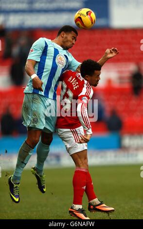 Cyrus Christie di Coventry City vince un titolo da Nicky Ajose di Swindon Town durante la partita della Sky Bet League One al County Ground di Swindon. Foto Stock