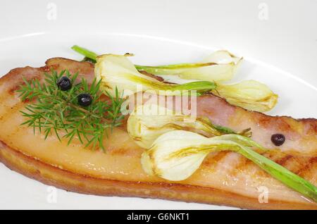 Pancetta fritta con la cipolla e il ginepro nel piatto Foto Stock