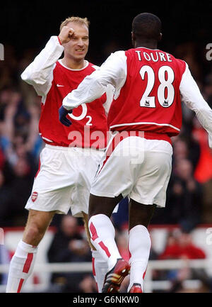 Dennis Bergkamp di Arsenal (a sinistra) celebra il suo obiettivo con il compagno di squadra Kolo Toure durante la sua partita di Barclaycard Premiership contro Blackburn a Highbury, a nord di Londra. Foto Stock