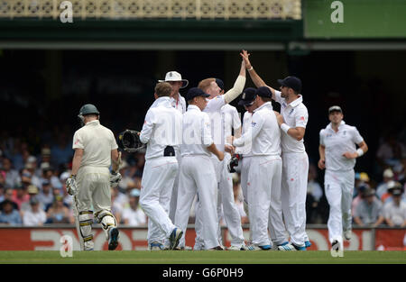 Il ben Stokes (centro) dell'Inghilterra celebra il lancio del cazzo australiano Chris Rogers (a sinistra) durante il primo giorno del quinto test al Sydney Cricket Ground, Australia. Foto Stock