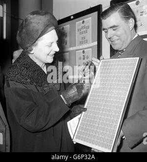 La sig.ra Mervyn Pike, assistente generale del Postmaster, esamina un foglio dei timbri britannici inesattamente perforati del mezzo penny a Stampex, l'esposizione nazionale del timbro che ha aperto alla sala centrale, Westminster, Londra. Foto Stock