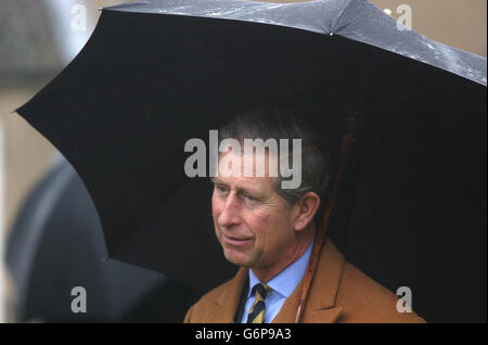 Prince of Wales ripara sotto un ombrello mentre visita la fattoria South Airmyn Grange a Goole nello Yorkshire orientale, dove ha visto il bestiame e piantato un albero di mele. Il Prince è in un tour di due giorni nello Yorkshire e nel North Lincolnshire. Foto Stock