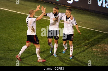 L'Ashkan Dejagah di Fulham (al centro) festeggia con i suoi compagni di squadra Patjim Kasami (a sinistra) e Alex Kacaniklic (a destra) dopo aver segnato il secondo obiettivo del gioco Foto Stock