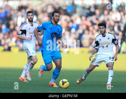 Mousa Dembele (centro) di Tottenham Hotspur corre con la palla mentre il Pozuelo di Swansea City (a destra) guarda sopra Foto Stock