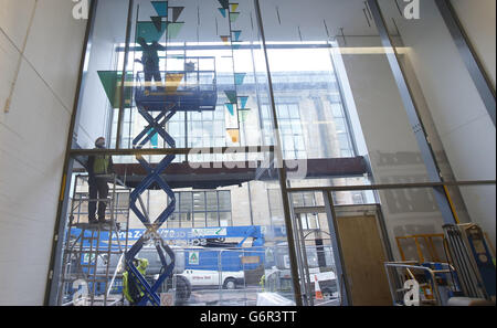 Graeme Raeburn (a destra) e Simon Hopkins installano un lavoro dell'artista vincitore del premio Turner Martin Boyce, all'ingresso del nuovo edificio Reid della Glasgow School of Art di Glasgow. Foto Stock