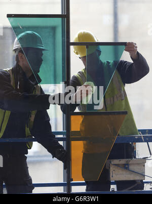 Graeme Raeburn (a sinistra) e Simon Hopkins installano un lavoro dell'artista vincitore del premio Turner Martin Boyce, all'ingresso del nuovo edificio Reid della Glasgow School of Art di Glasgow. Foto Stock