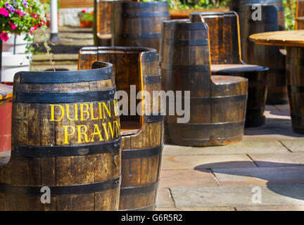 Patio whiskey riciclati o whisky botti utilizzate come tavoli e sedie in un ristorante locale per cenare al-fresco. Southport, Regno Unito Foto Stock